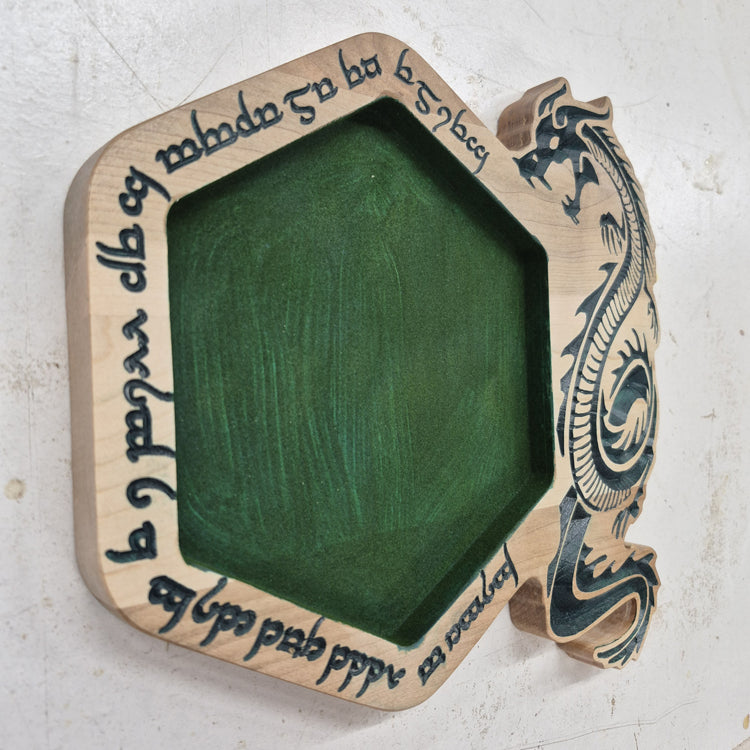 An angled side shot of the hexagonal Runic Dragon wooden dice tray, highlighting the clean depth of the runic carvings and the rich contrast of the hand-painted green details against the natural hardwood grain.