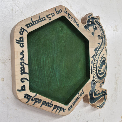 An angled side shot of the hexagonal Runic Dragon wooden dice tray, highlighting the clean depth of the runic carvings and the rich contrast of the hand-painted green details against the natural hardwood grain.