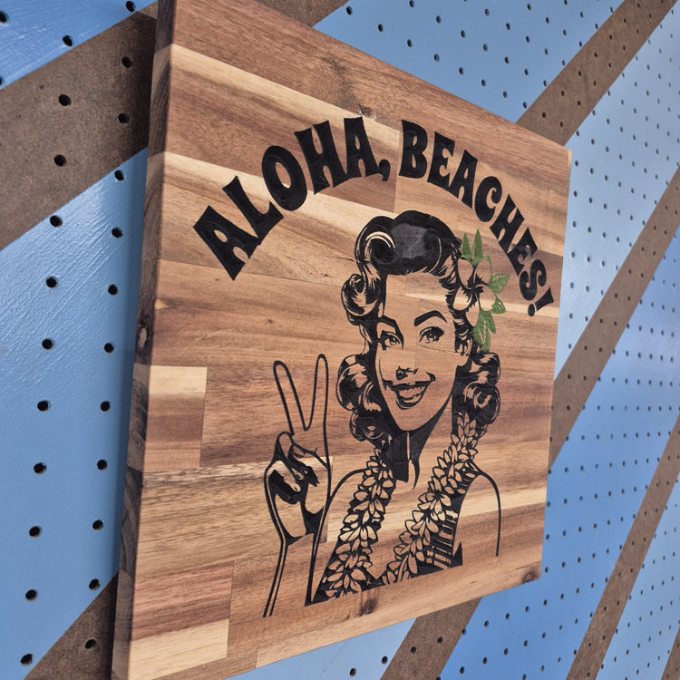 Angled Shot showing CNC Carved plaque saying Aloha, Beaches! with a 50's Pinup showing a Peace sign