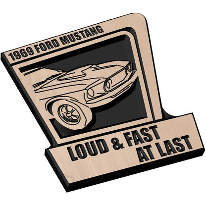 Angled shot of a Handcrafted relief-carved hardwood sign featuring a 1969 Ford Mustang and the text "LOUD & FAST AT LAST," fully customizable to showcase your favorite vehicle and personal messaging.