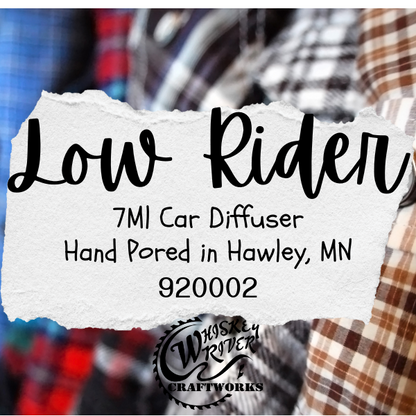 Product label for 'Low Rider 7MI Car Diffuser' with Whiskey River Craftworks branding, set against a plaid fabric background.