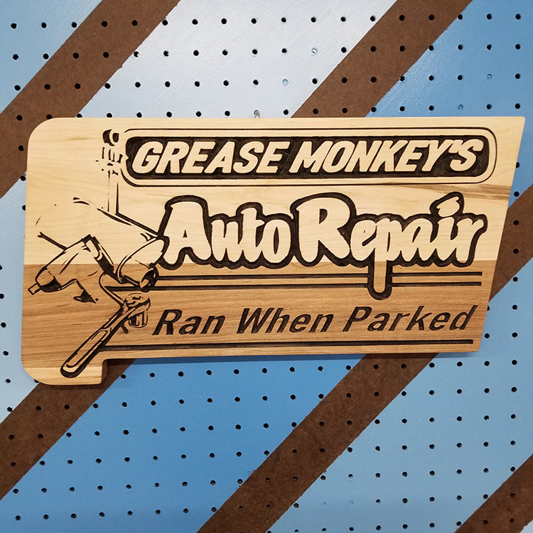 Handcrafted relief-carved hardwood sign featuring the text "Grease Monkey's Auto Repair: Ran When Parked"