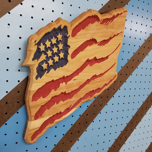 Angled shot of a Handcrafted relief-carved hardwood "Claw Flag" sign featuring a distressed, stylized American flag design.