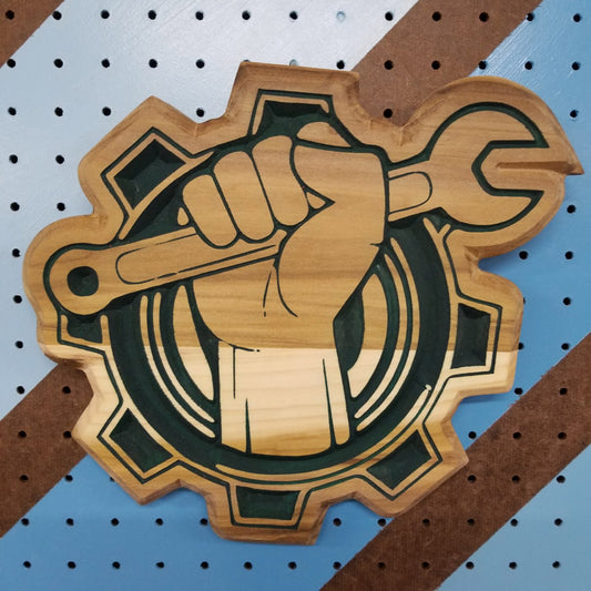 Relief carved hardwood sign featuring a fist clutching a wrench in a bold, mechanic-style design.