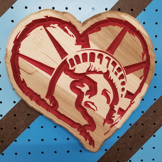 Relief carved hardwood heart-shaped sign featuring a detailed Statue of Liberty profile design painted red