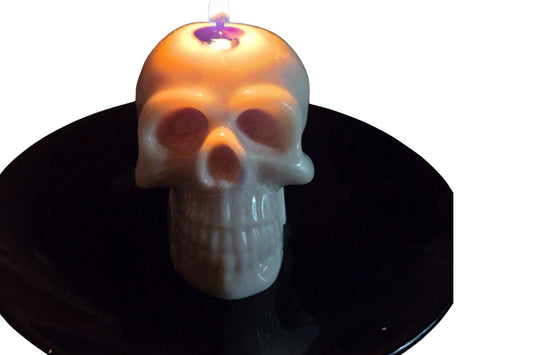 Handcrafted artisan skull candle with a color-bleeding core, designed to release vibrant wax colors as it burns, creating a striking piece of dark gothic decor.