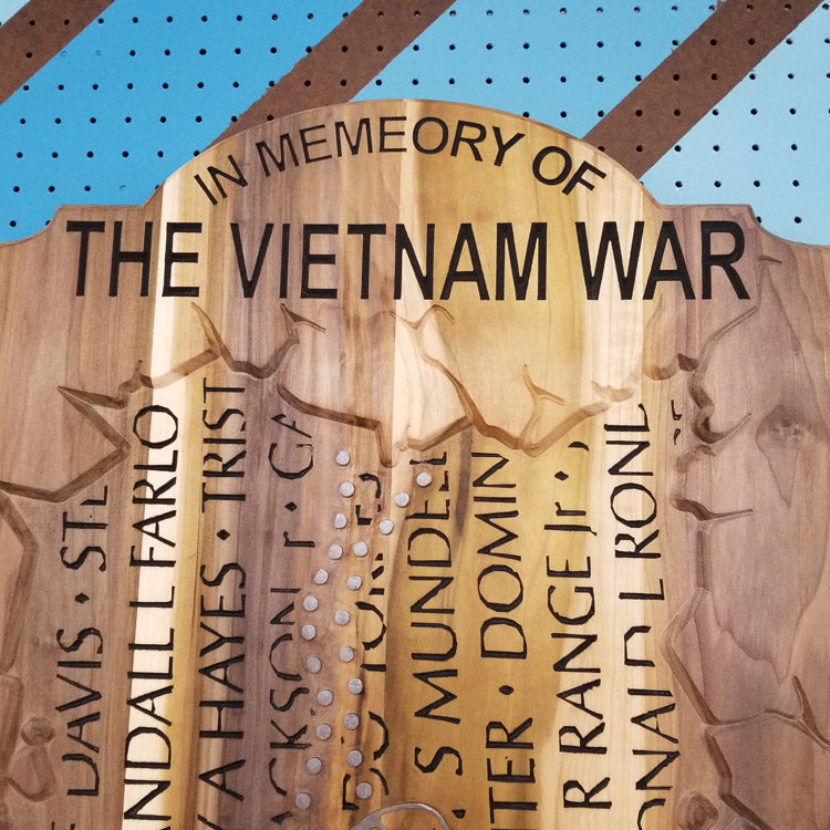 Close-up of a custom hardwood Vietnam War memorial sign featuring the carved header text In Memory Of The Vietnam War.