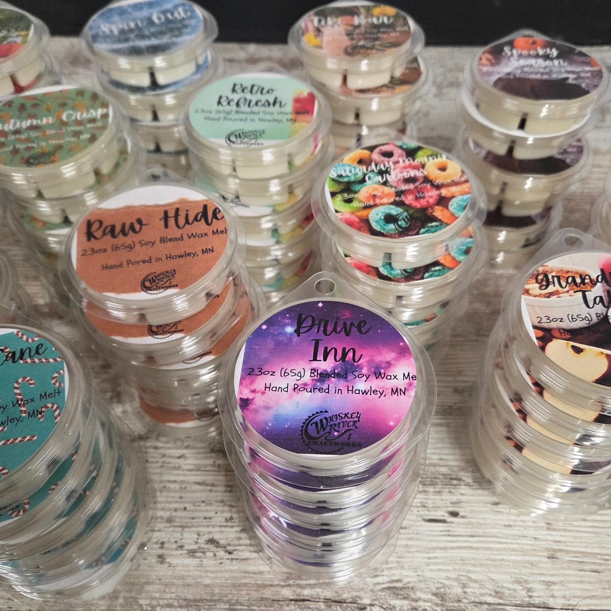 Hand-poured artisan soy wax melts in clear clamshell packs with retro fragrance labels on a wooden surface.